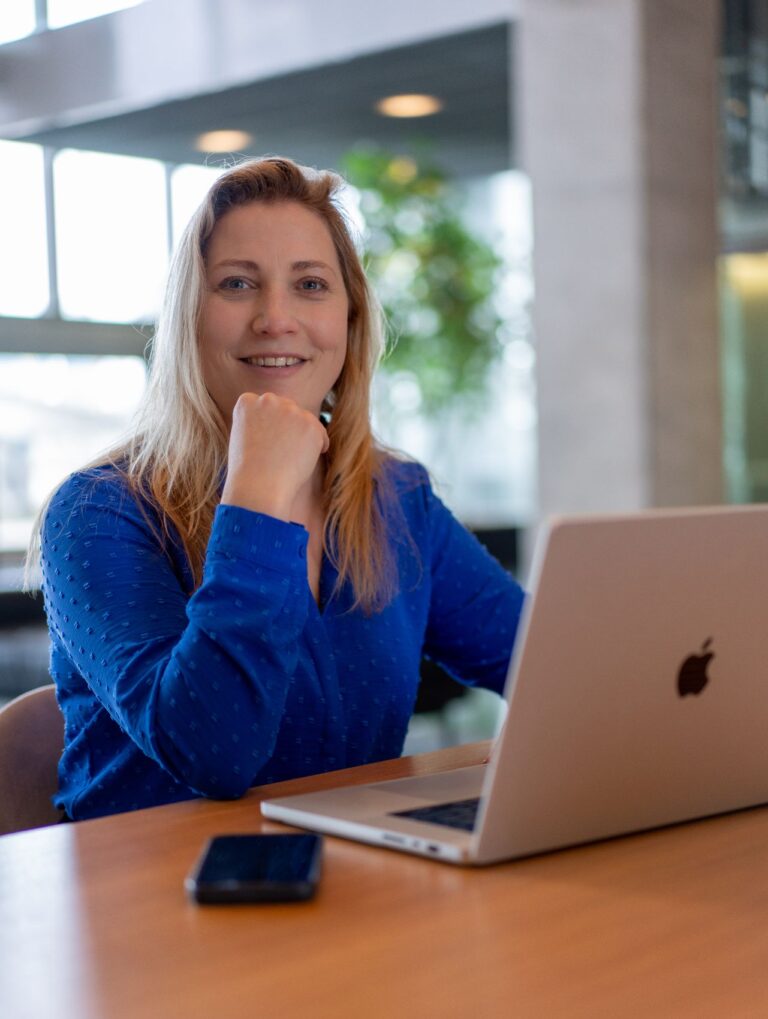 Vrouw werkt en kijkt in de camera